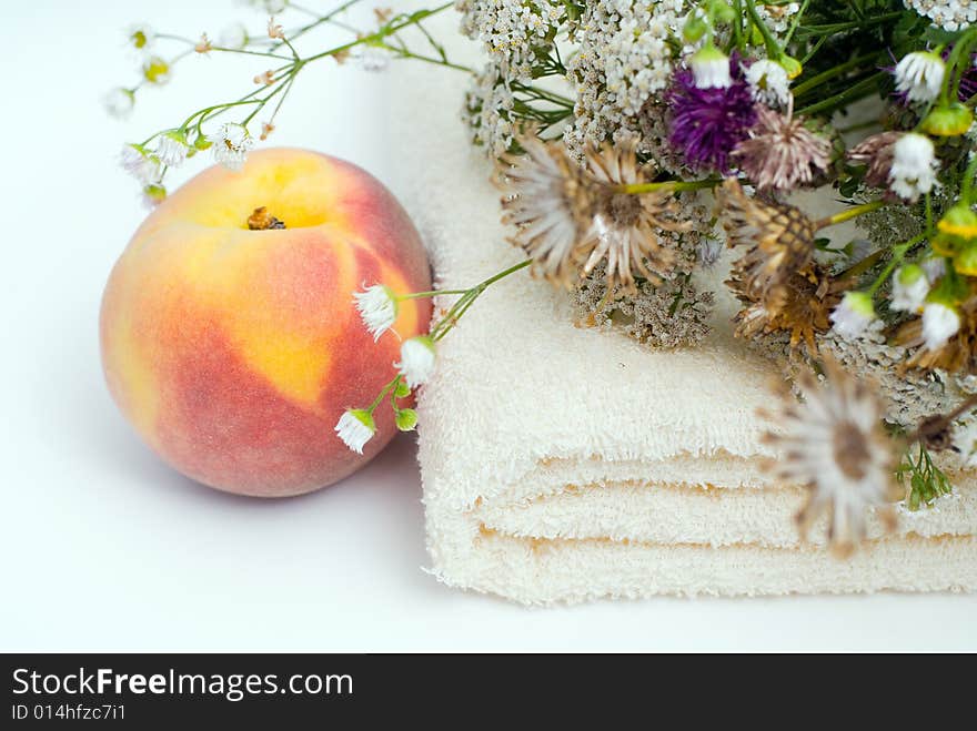 Healthy lifestyle background with peach, towel and flowers. Healthy lifestyle background with peach, towel and flowers