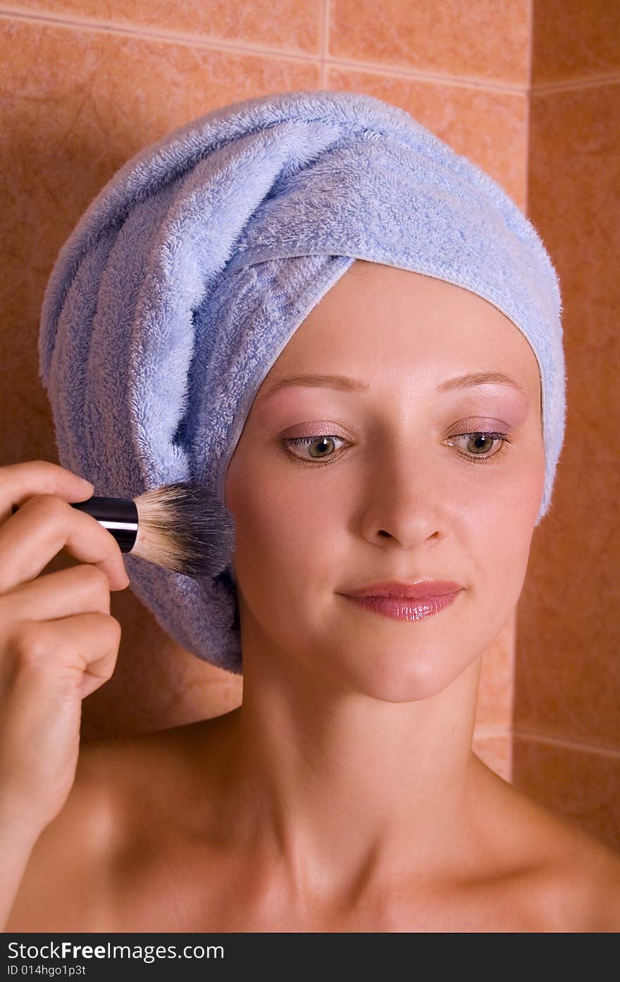 Beautiful girl doing make-up in bathroom. Portrait.