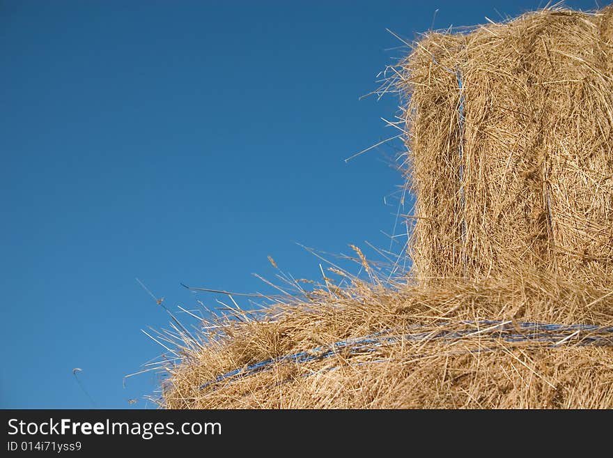 Two bales of hay in a blue sky