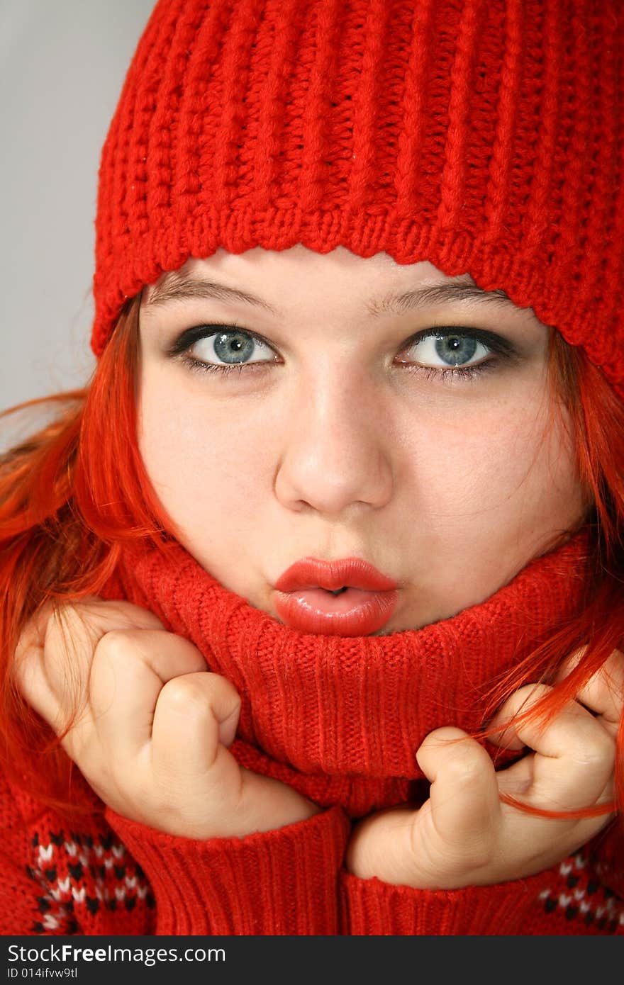 Young girl hides into the collar of the red sweater. Young girl hides into the collar of the red sweater