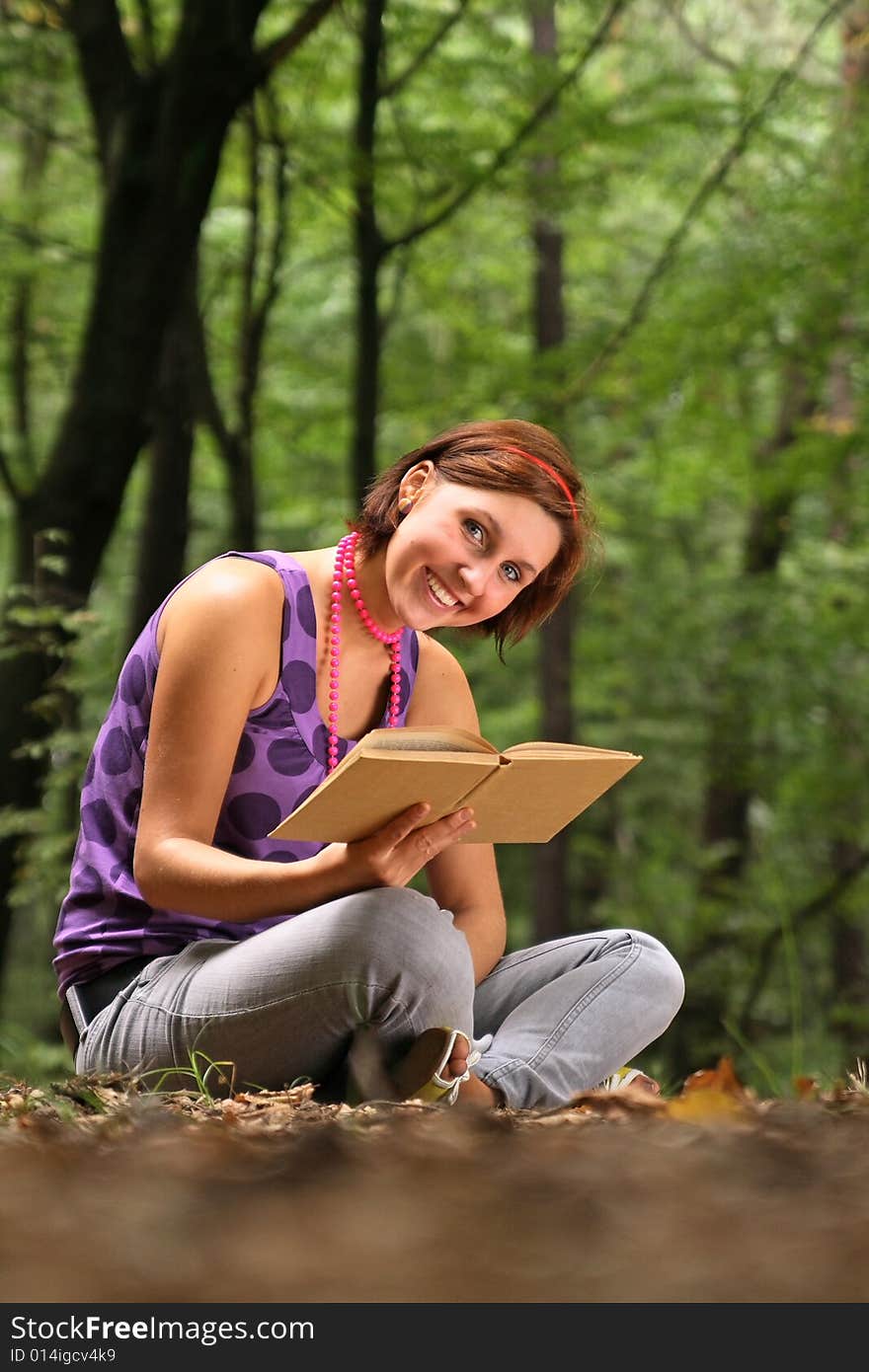 Young pretty girl reading a book.