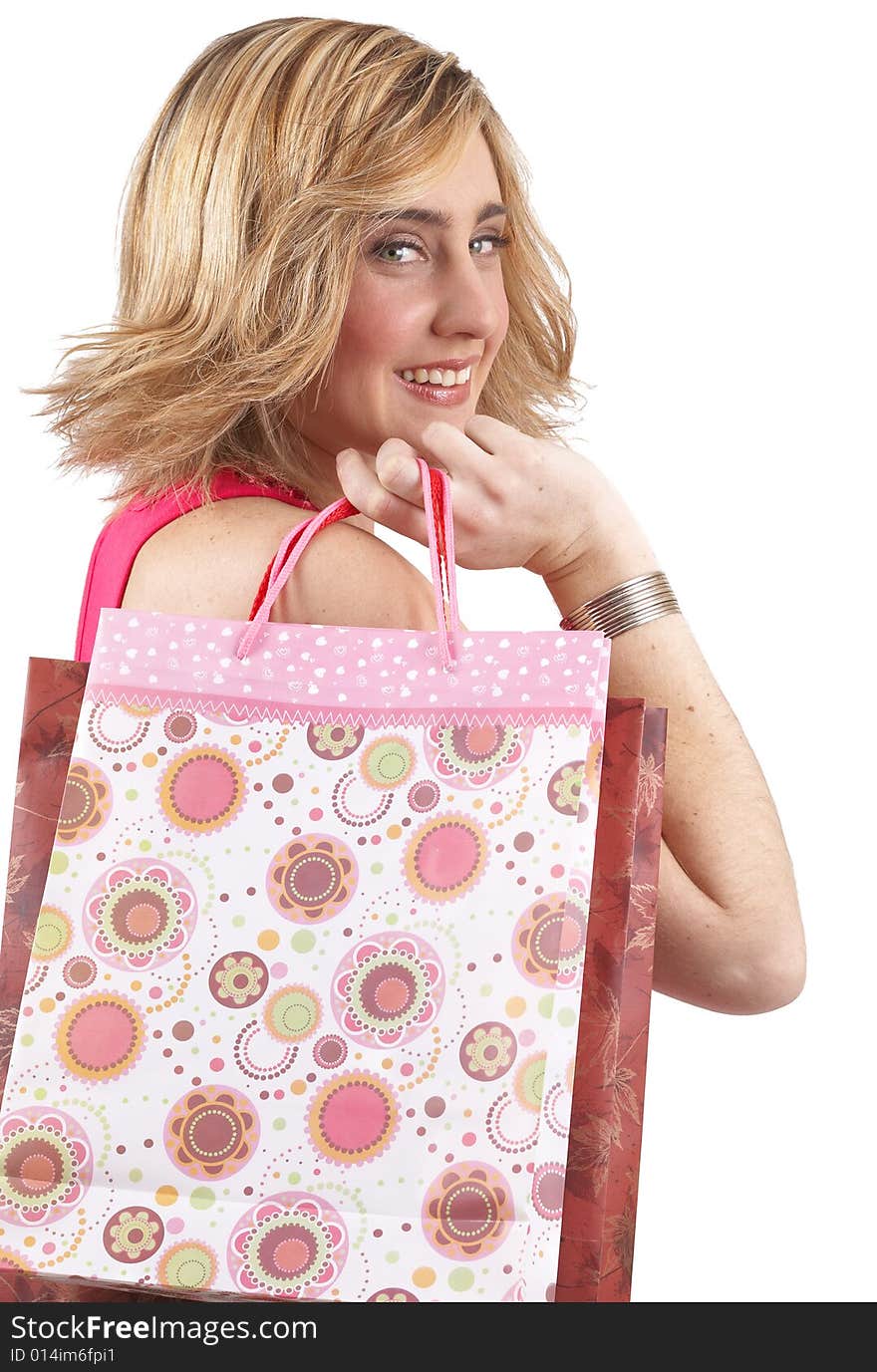 Portrait of a beautiful young blonde woman wearing a pink fashionable top and holding shopping bags over her shoulder. Isolated on white background. Portrait of a beautiful young blonde woman wearing a pink fashionable top and holding shopping bags over her shoulder. Isolated on white background