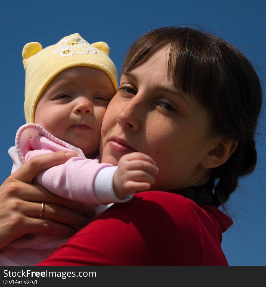 Baby with mom on blue sky background