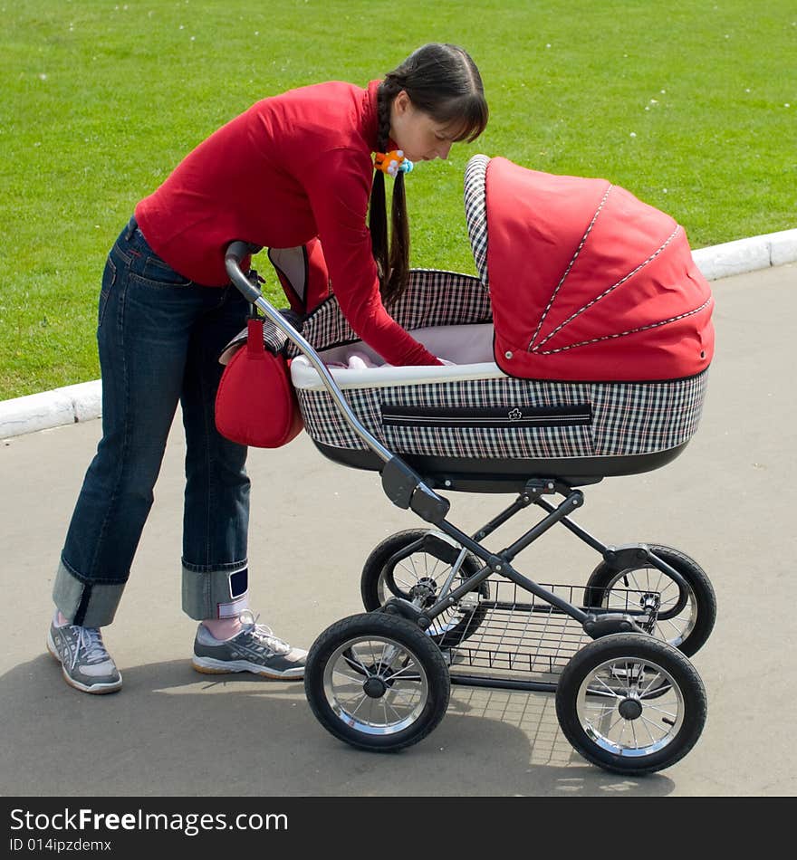 Young woman with red baby carriage. Young woman with red baby carriage