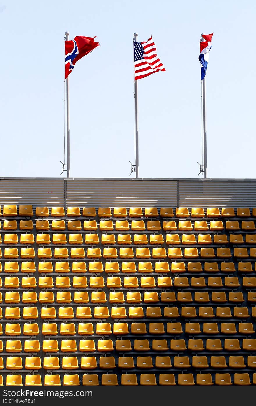 Flags and the stand with yellow seats. Flags and the stand with yellow seats.