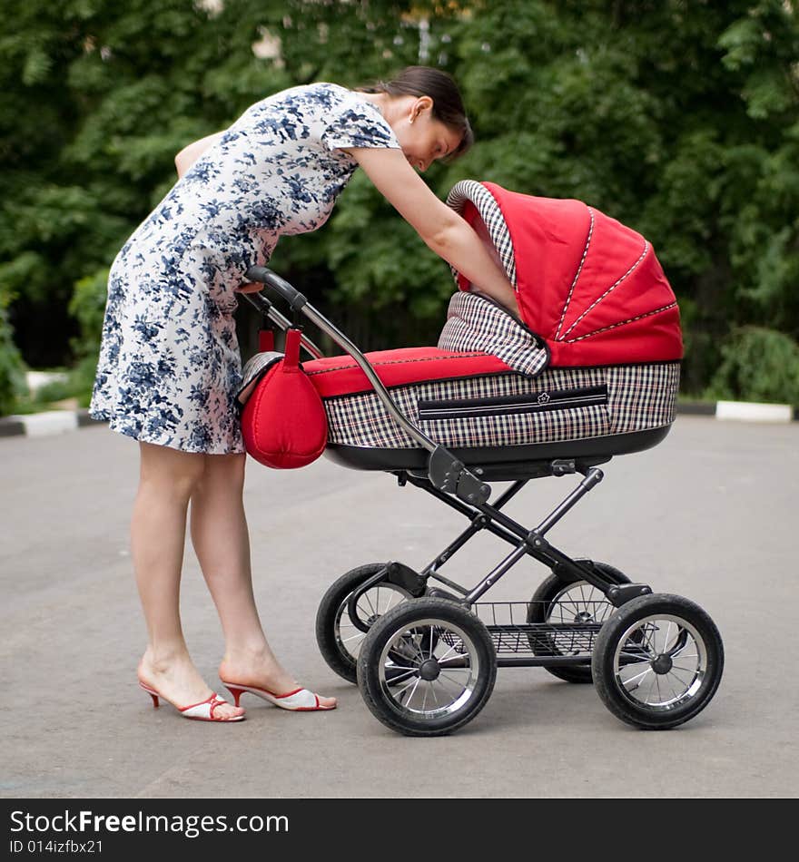 Young woman with red baby carriage. Young woman with red baby carriage