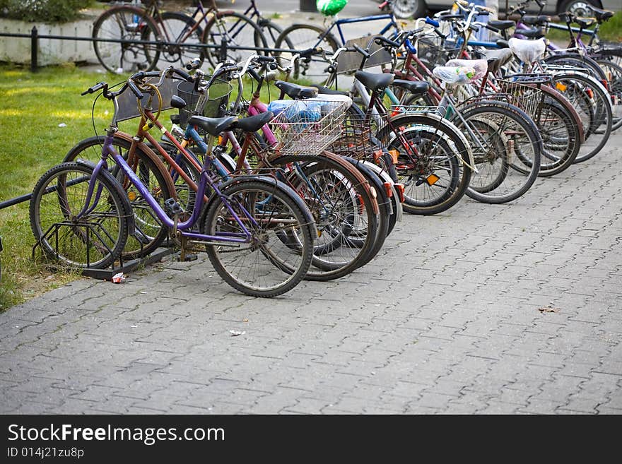 Many Bikes parked on street. Sharp focus on a few first bicycles. Many Bikes parked on street. Sharp focus on a few first bicycles