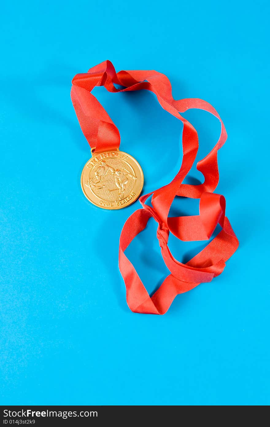 Gold medal with red ribbon on blue background