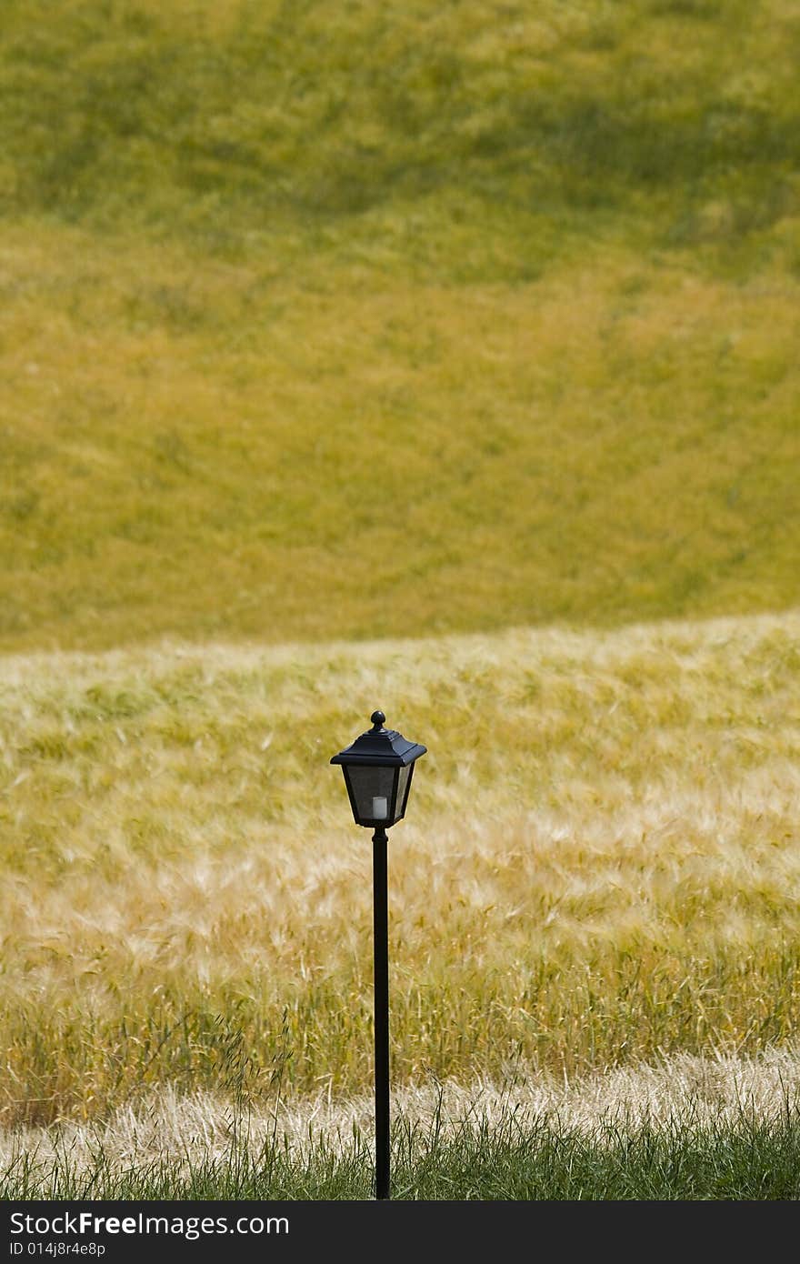 Tuscany countryside, green meadow and close-up ancient street lamp. Tuscany countryside, green meadow and close-up ancient street lamp