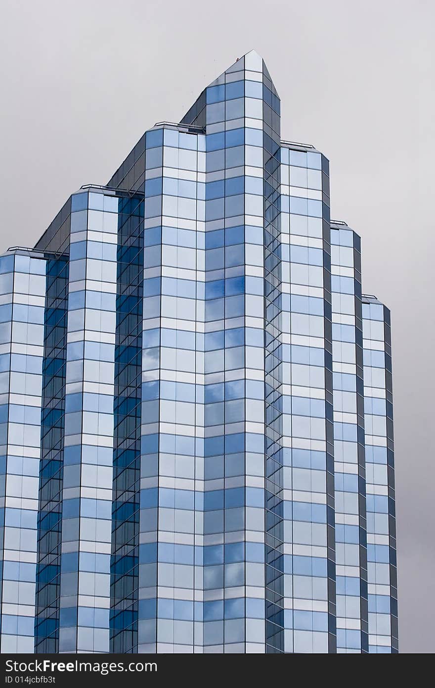 A modern blue and grey glass building on a grey background. A modern blue and grey glass building on a grey background