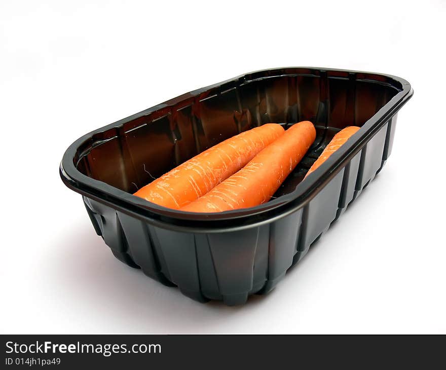 Wrapped carrot in a black plastic box isolated on a white background.