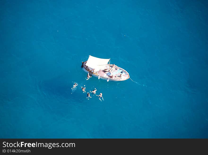 Famyli's people swimming in the sea near their boat. Famyli's people swimming in the sea near their boat