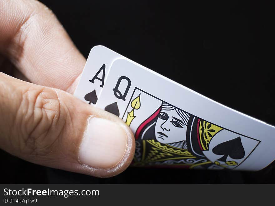 Blackjack cards held by hand against black background. Blackjack cards held by hand against black background