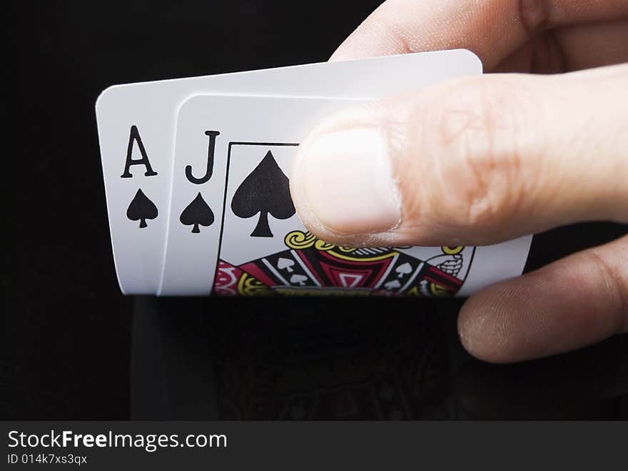 Blackjack cards held by hand against black background. Blackjack cards held by hand against black background