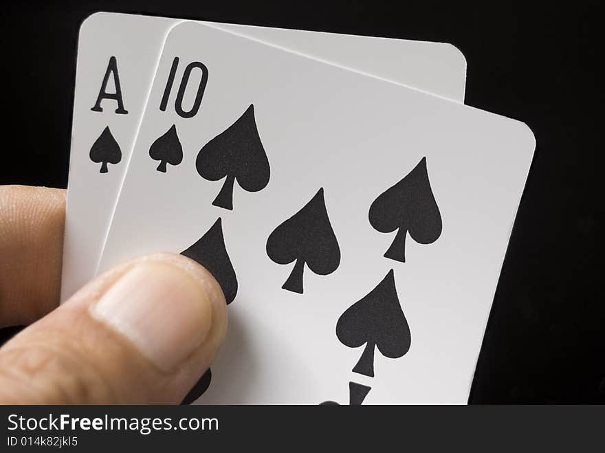 Blackjack cards held by hand against black background. Blackjack cards held by hand against black background