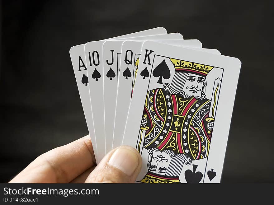 Royal Flush held by hand against black background. Royal Flush held by hand against black background