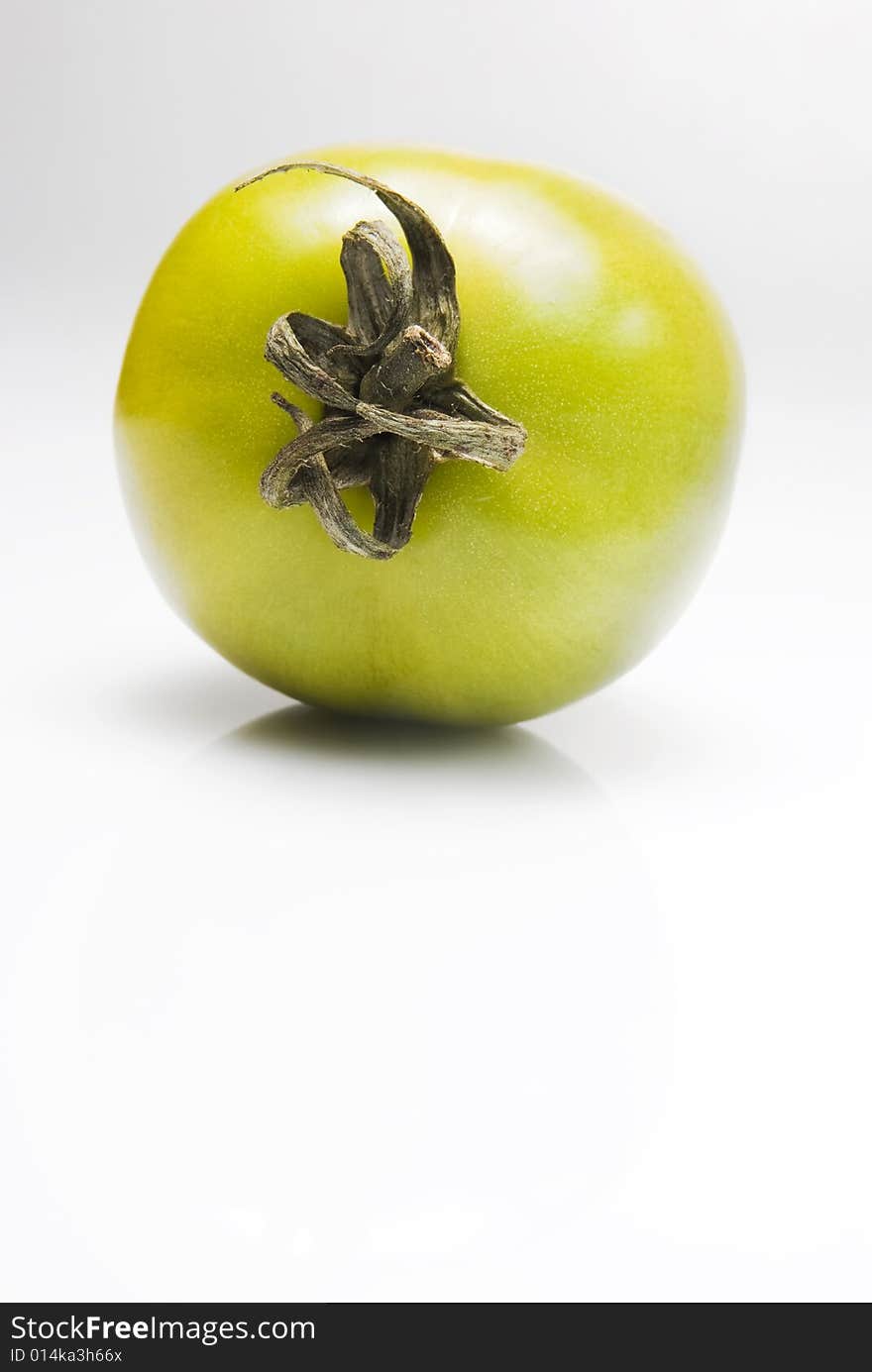 Green tomato shot against white background