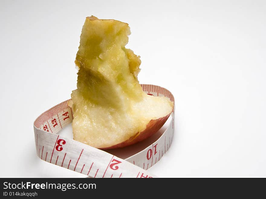 Studio shot of apple and measuring tape against white background. Studio shot of apple and measuring tape against white background