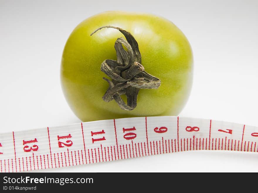 Studio shot of tomato and measuring tape. Studio shot of tomato and measuring tape