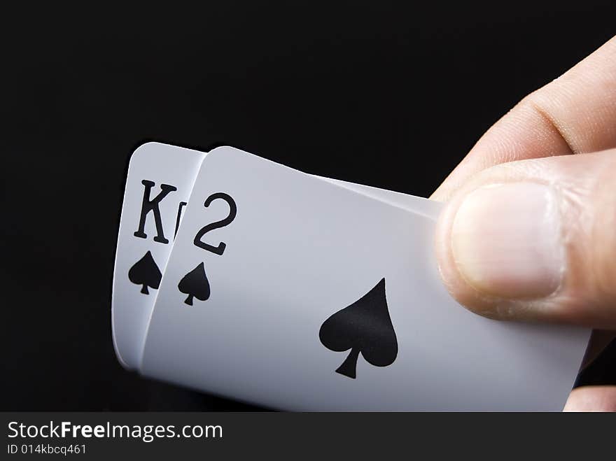 Blackjack cards held by hand against black background. Blackjack cards held by hand against black background