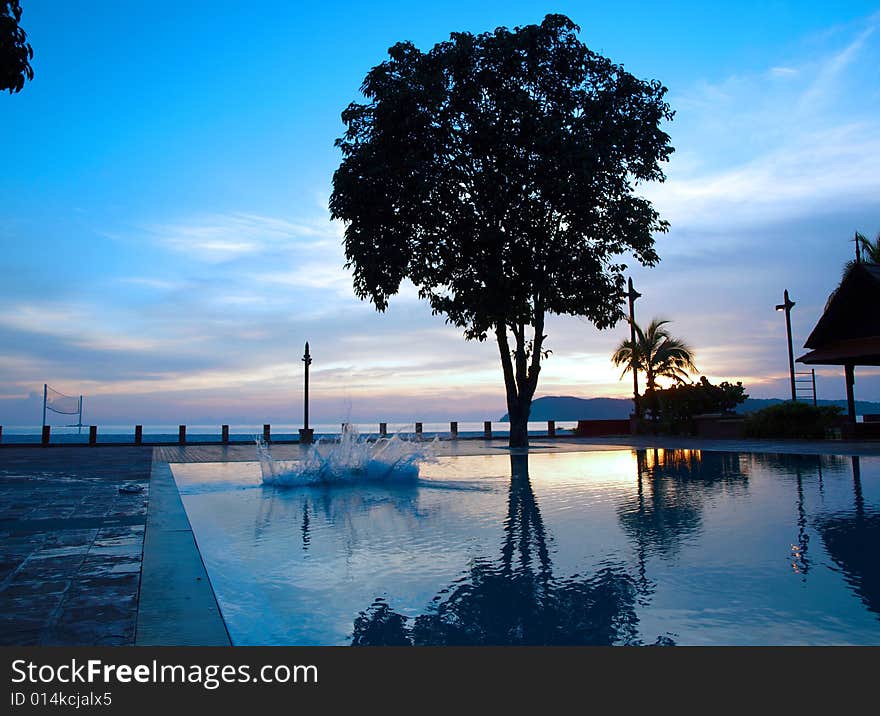 Splash into Pool during dusk at holiday resort. Splash into Pool during dusk at holiday resort