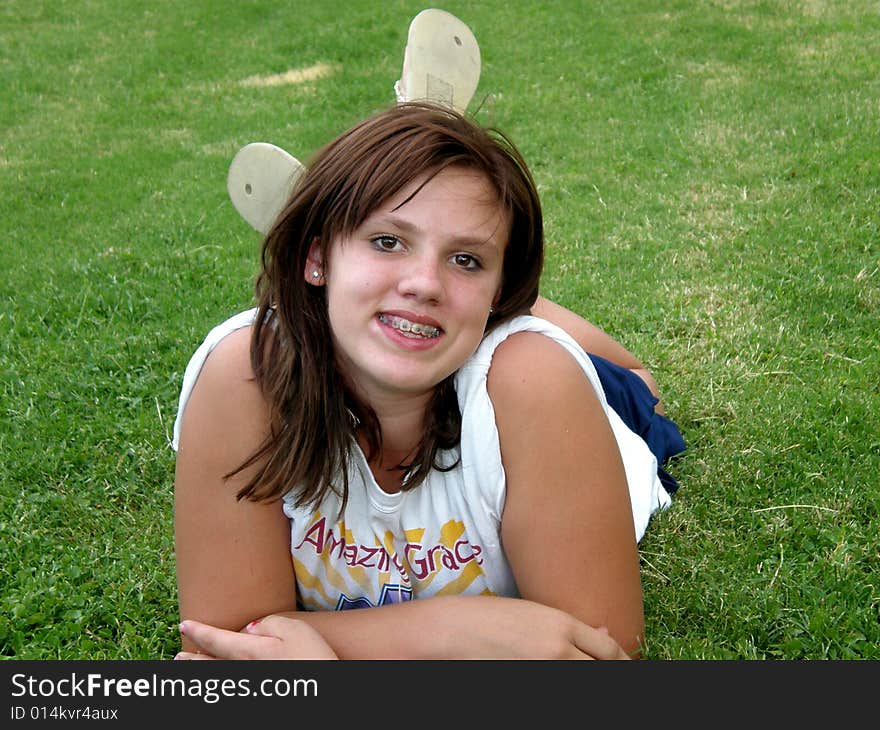 A picture of a young teen girl laying in the grass. A picture of a young teen girl laying in the grass.