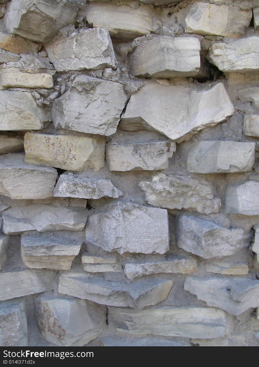 An old shabby stone wall. An old shabby stone wall