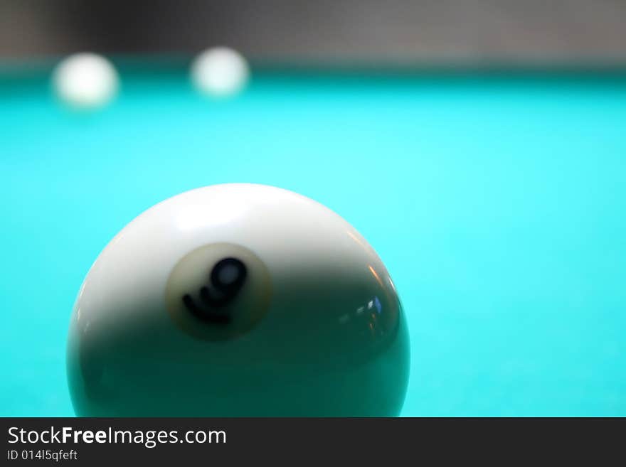 White billiard ball on a green background