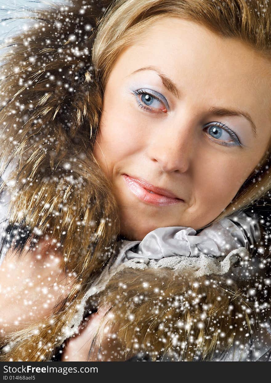 Beautiful girl with blue eyes in fur hood and snow. Beautiful girl with blue eyes in fur hood and snow