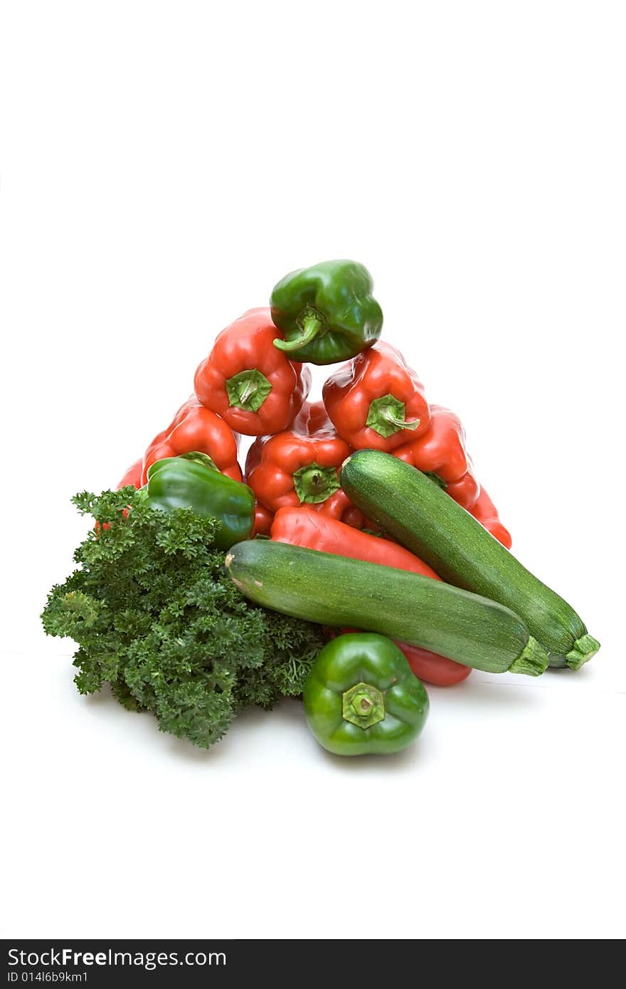 A pyramid, grouping of fresh raw vegetables, zucchini, bell peppers, red, green, parsley,. A pyramid, grouping of fresh raw vegetables, zucchini, bell peppers, red, green, parsley,