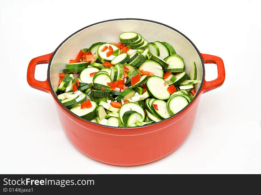 A large cast iron enameled pot filled with fresh garden chopped zucchini, red peppers, green peppers, onions and garlic being prepared for a pasta sauce. A large cast iron enameled pot filled with fresh garden chopped zucchini, red peppers, green peppers, onions and garlic being prepared for a pasta sauce.