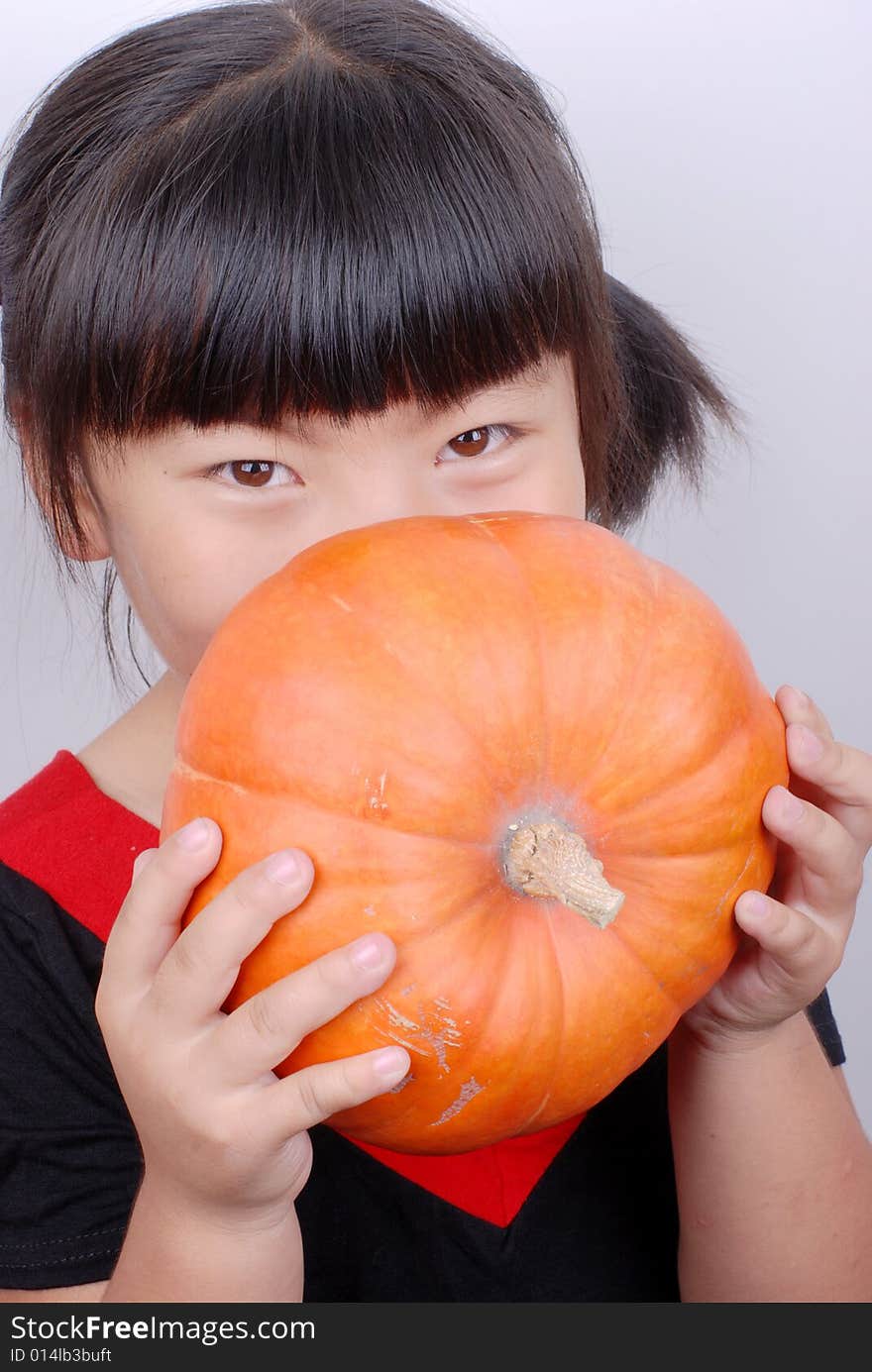 Asia girl smiling behind pumpkin. Asia girl smiling behind pumpkin