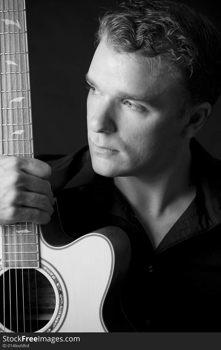 Portrait of young musician holding his guitar