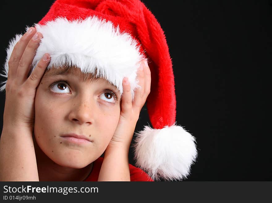 Young boy wearing a red shirt and christmas hat. Young boy wearing a red shirt and christmas hat