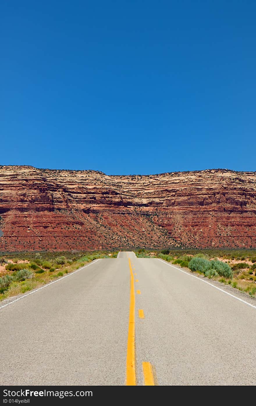 An image of a desert highway leading into amazing mountains. An image of a desert highway leading into amazing mountains