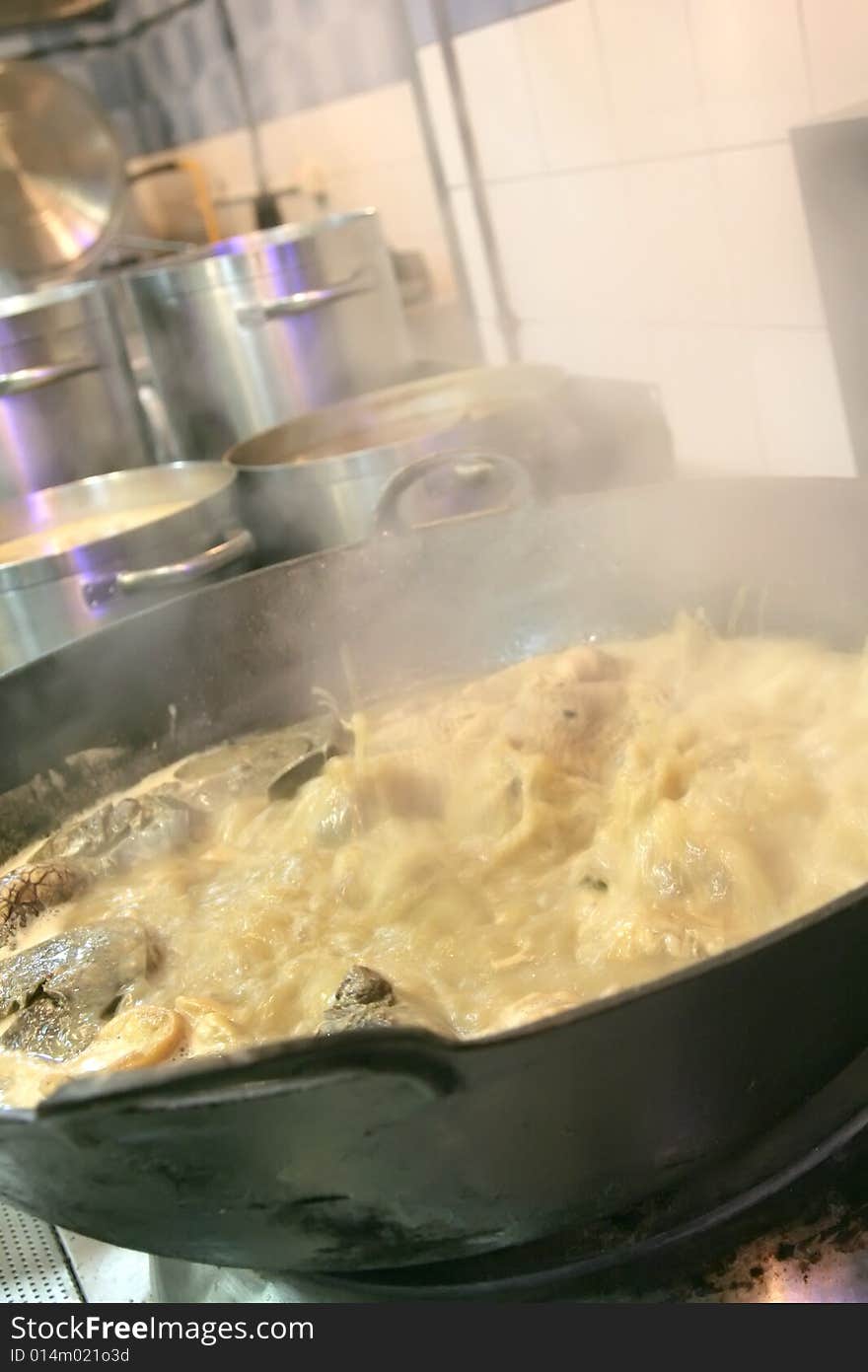 Boiling food at restaurant kitchen with smoke come out from wok. Boiling food at restaurant kitchen with smoke come out from wok