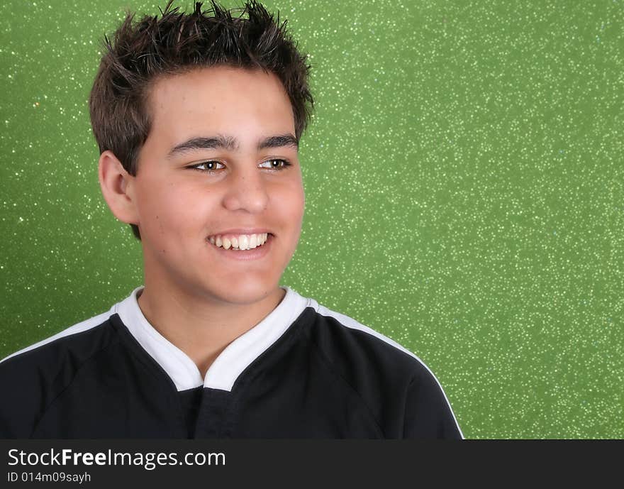 Brunette teenage male against a green background. Brunette teenage male against a green background