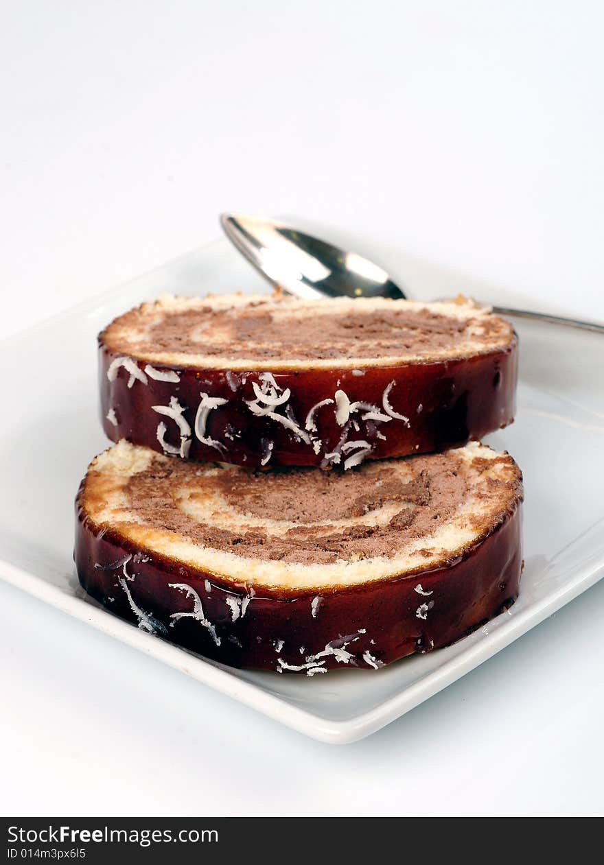 Chocolate cake in a square plate over white background