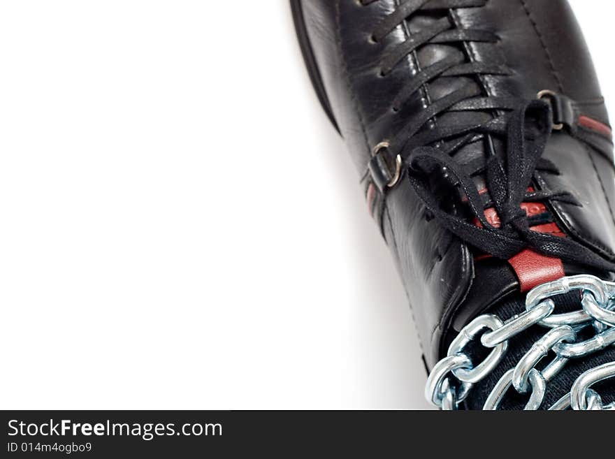 Metal chain on man feet, copy space for the text, concept photo. Metal chain on man feet, copy space for the text, concept photo