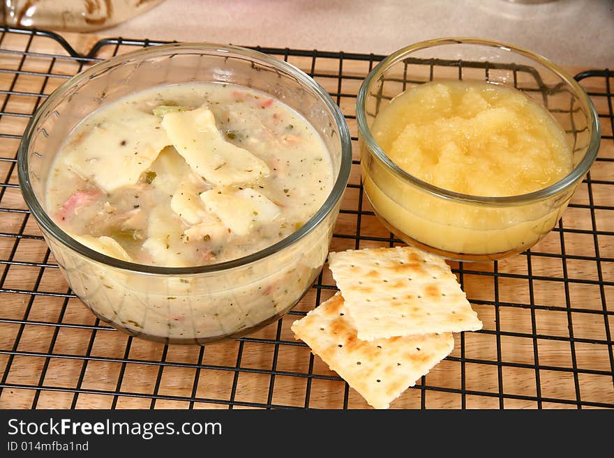 Chicken dumplings in kitchen or restaurant.  Applesauce, crackers.