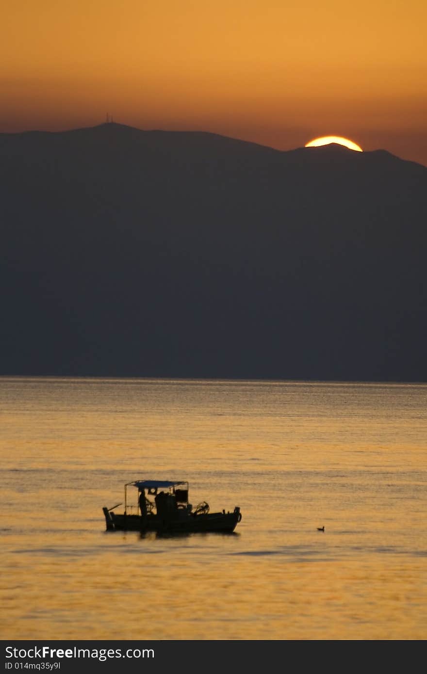 Surise over Greece seen from Corfu island with sailors in foreground. Surise over Greece seen from Corfu island with sailors in foreground