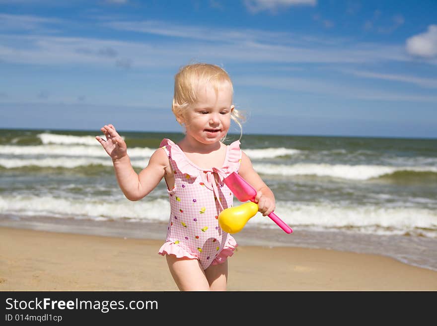 Small girl with toys on the seashore. Small girl with toys on the seashore