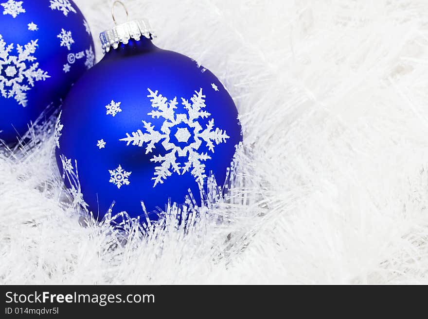 Blue glass ball on white shiny garland making a background, Christmas background. Blue glass ball on white shiny garland making a background, Christmas background