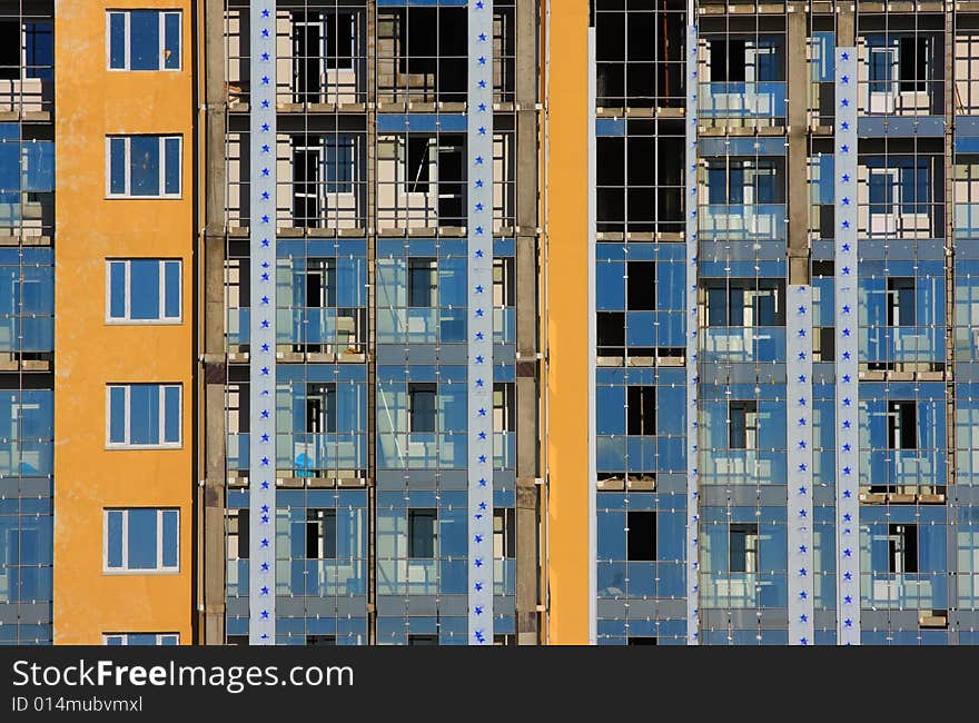 New building. Yellow and blue. Dirt windows