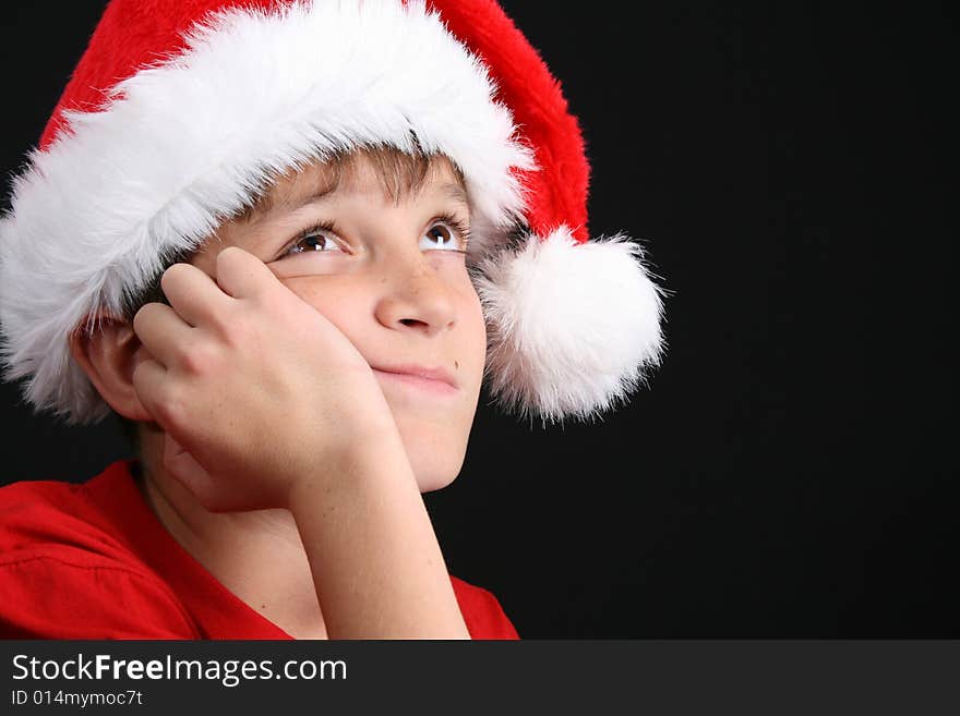 Young boy wearing a red shirt and christmas hat. Young boy wearing a red shirt and christmas hat