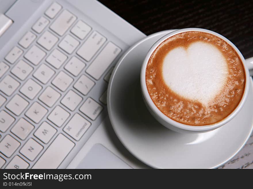 Cappucino with heart shape on pc's keyboard