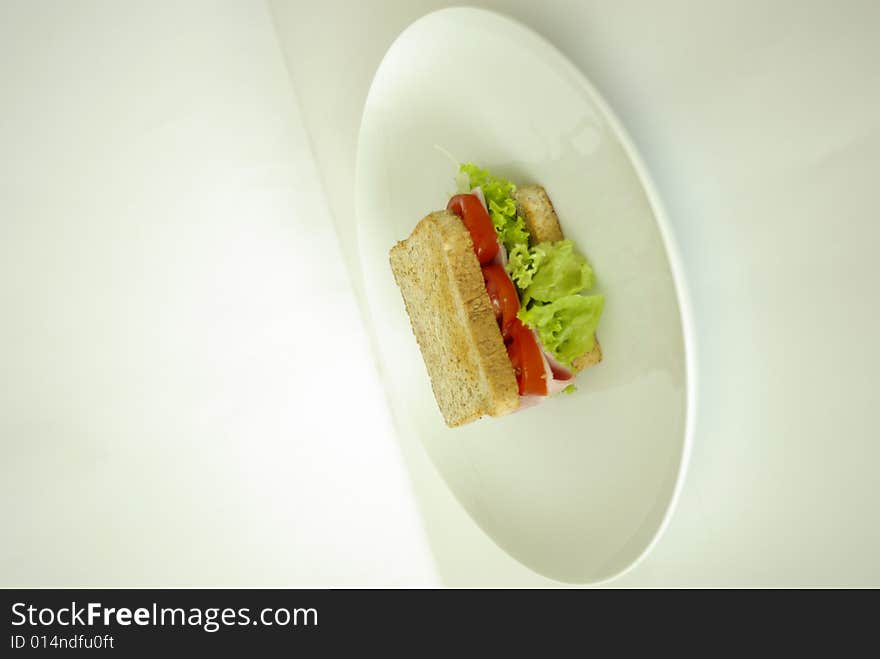 A close up view of a sandwich with salad tomatoes and ham