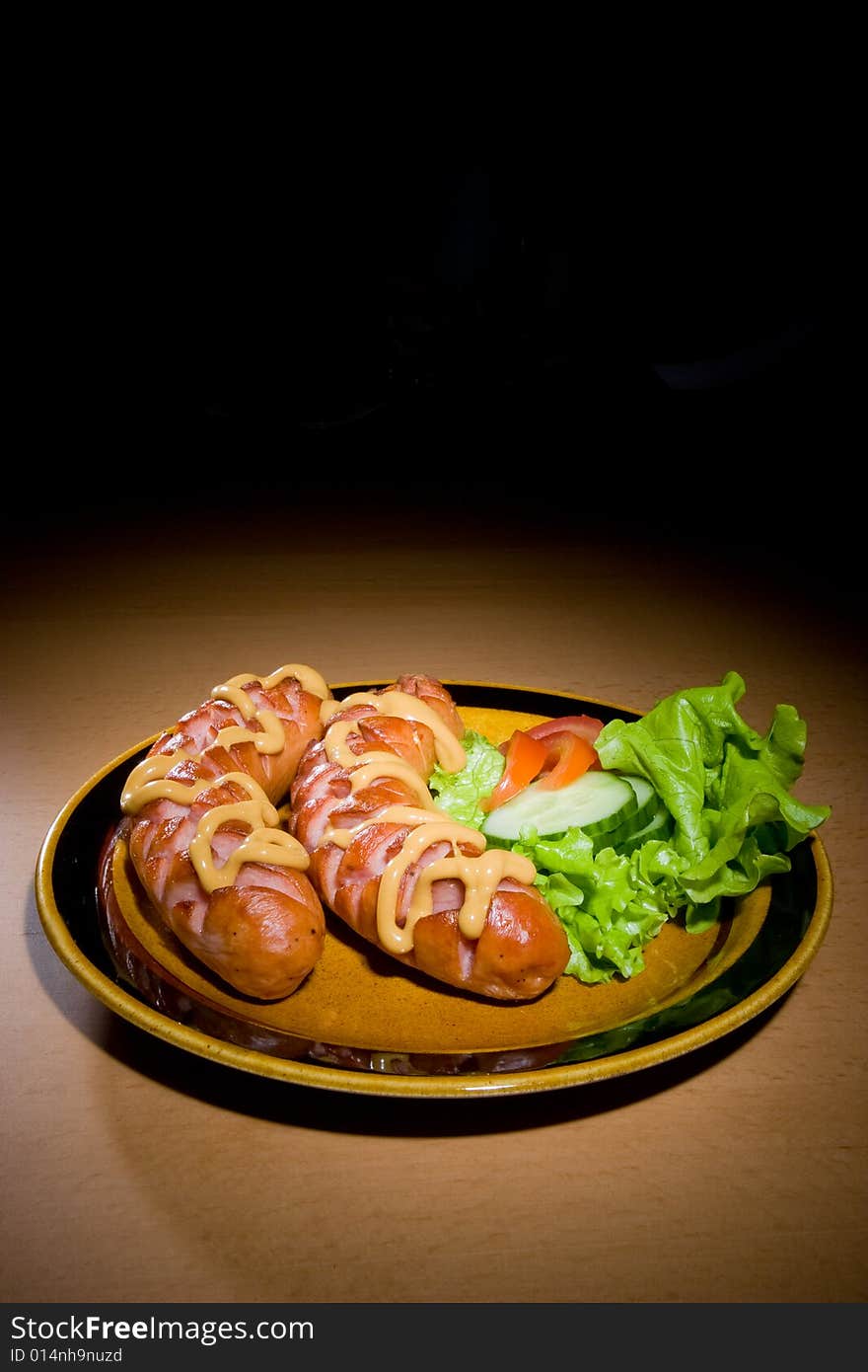 Sausages on plate with tomatoes and salad. Sausages on plate with tomatoes and salad