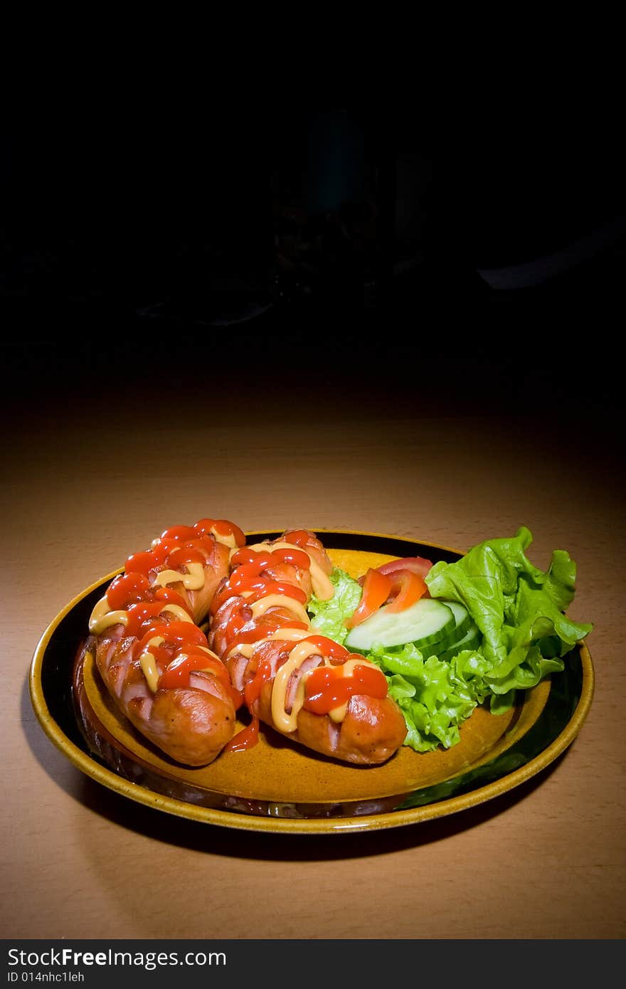 Sausages on plate with mustard and ketchup. Sausages on plate with mustard and ketchup