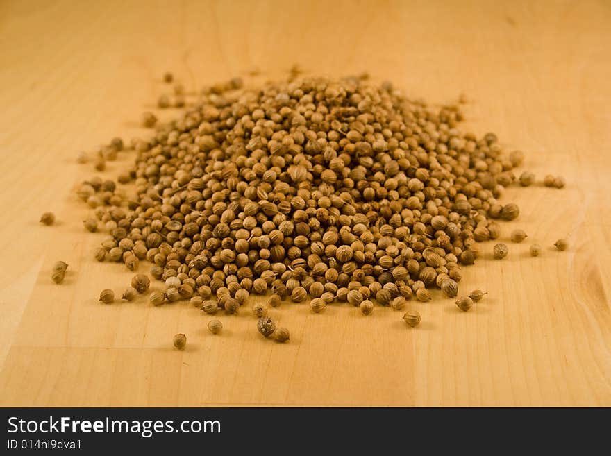 Coriander seeds on wooden block